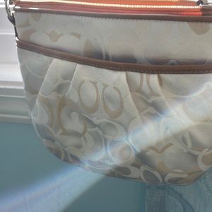 Coach crossbody small bag with light color monogram and a outside pocket